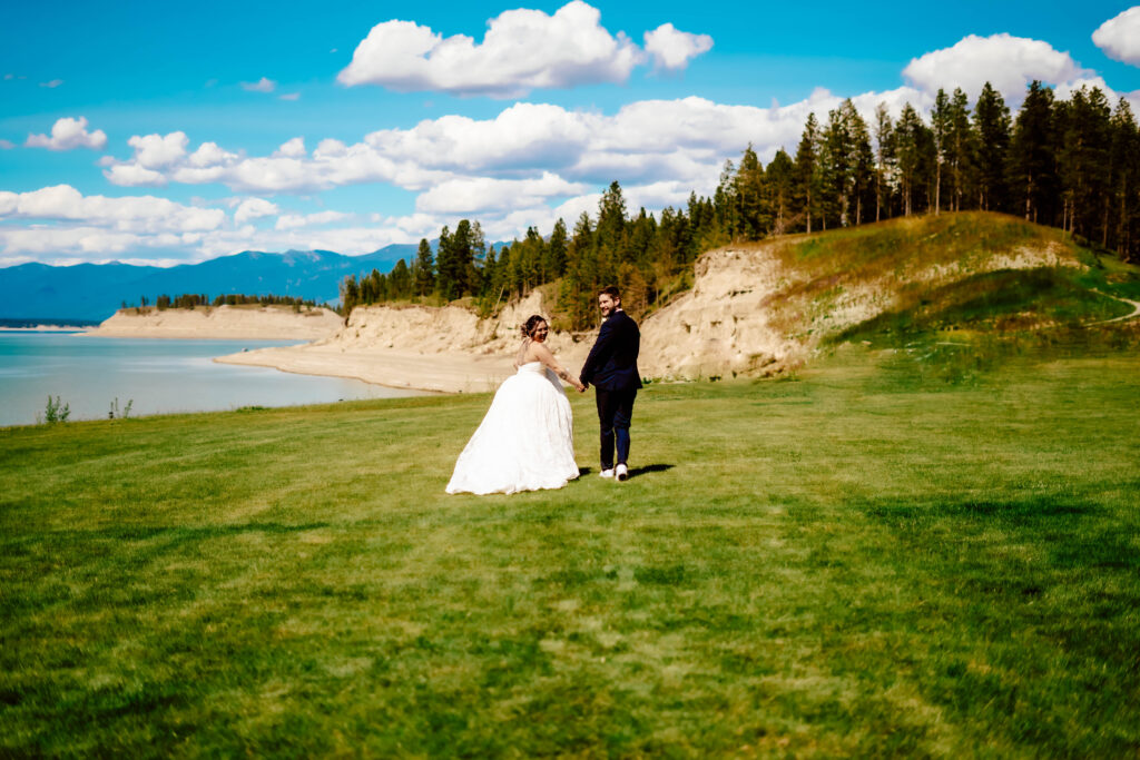 Elopement couple near the shore with cliffs in the background.