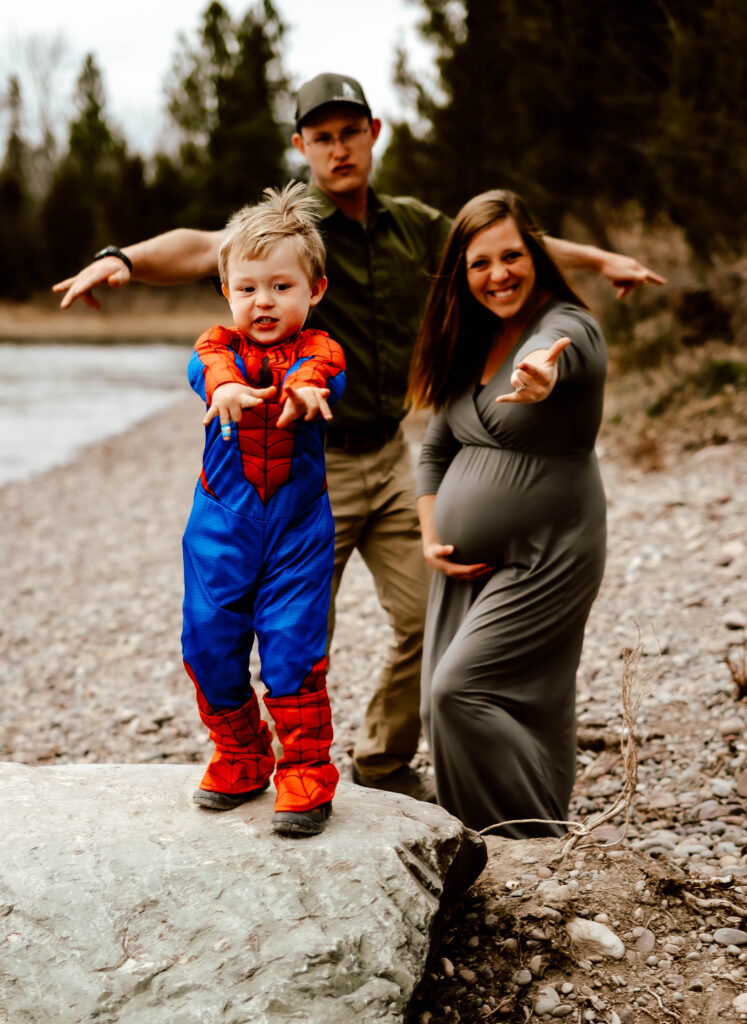 Kid in spiderman costume posing for adventure family maternity session.