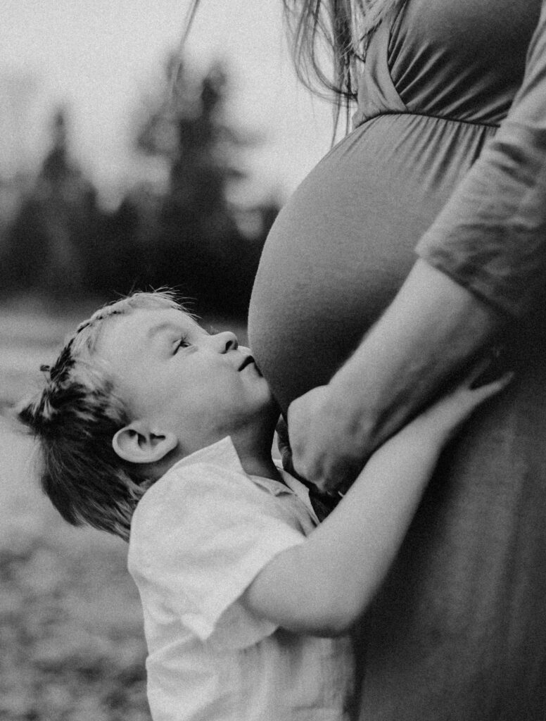 Son kissing mommy's belly. Maternity Photo.