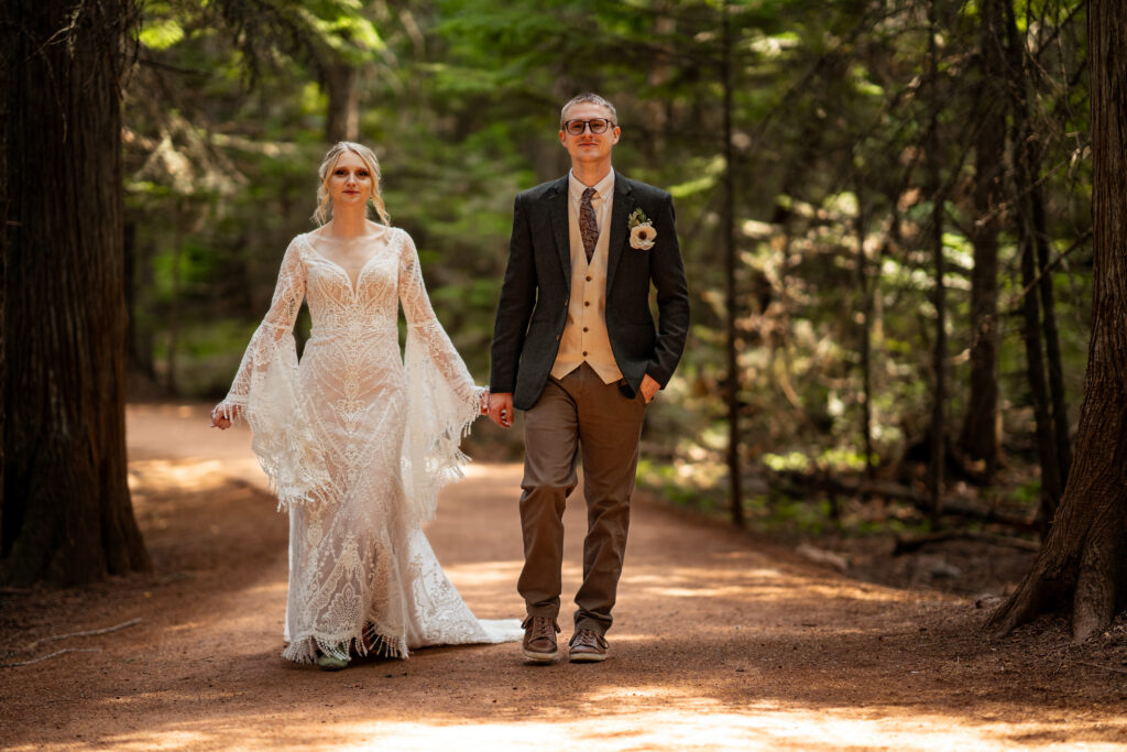 elopement couple walking in cedar trees