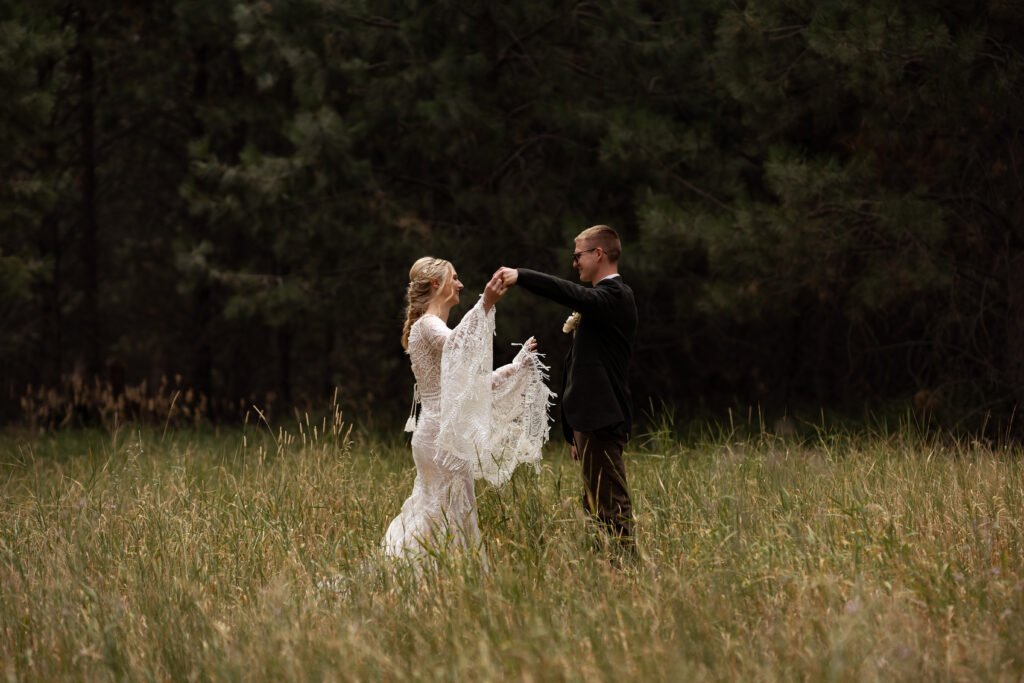 bride and groom dancing in a field